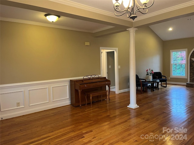 interior space featuring an inviting chandelier, hardwood / wood-style flooring, ornate columns, and crown molding