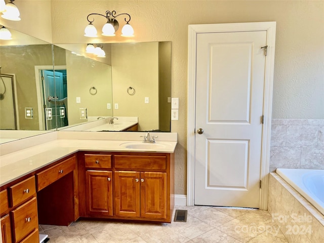 bathroom featuring vanity, tile patterned floors, and tiled tub