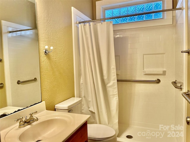 bathroom with a shower with shower curtain, vanity, and toilet