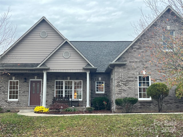 view of front facade featuring a front yard and covered porch