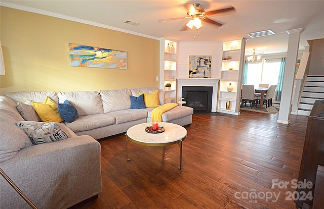 living room with dark wood-type flooring, ceiling fan, ornamental molding, and built in shelves