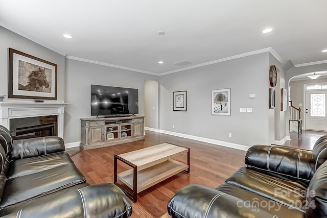 living room with a fireplace, hardwood / wood-style flooring, and ornamental molding