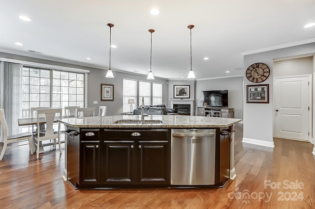 kitchen with dark brown cabinetry, stainless steel dishwasher, an island with sink, and light hardwood / wood-style flooring