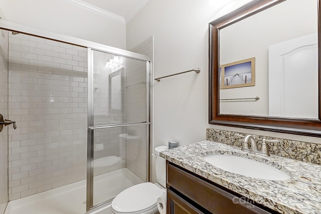 bathroom with toilet, vanity, a shower with door, and ornamental molding