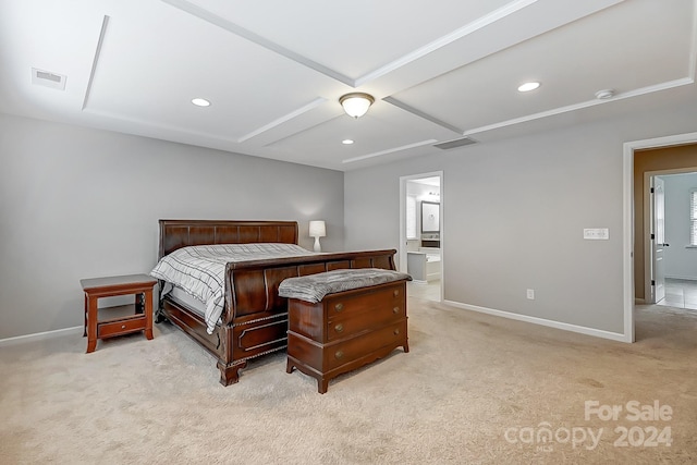 bedroom with light colored carpet and ensuite bath