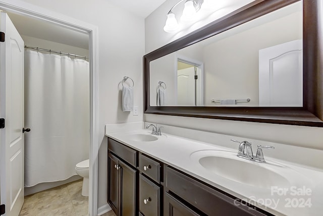 bathroom featuring toilet, vanity, and tile patterned flooring