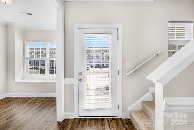 doorway to outside featuring wood-type flooring and ornamental molding