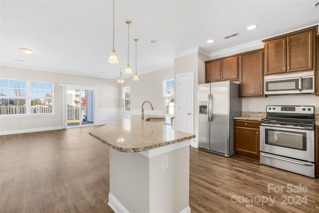 kitchen with light stone countertops, sink, appliances with stainless steel finishes, dark hardwood / wood-style flooring, and a kitchen island with sink