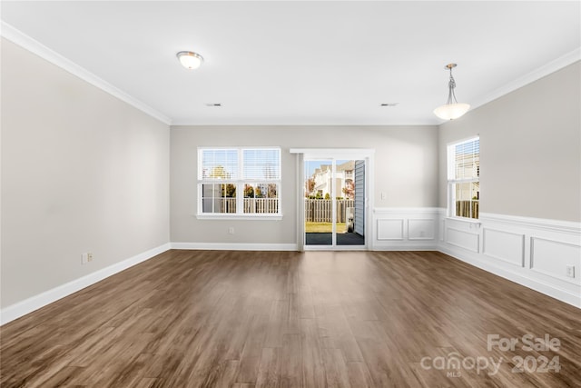 spare room with crown molding, dark hardwood / wood-style floors, and a healthy amount of sunlight