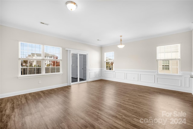 unfurnished room featuring crown molding, dark wood-type flooring, and plenty of natural light