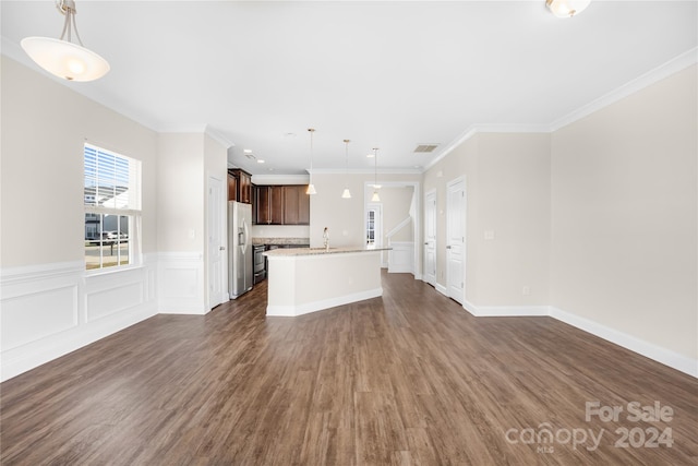 unfurnished living room featuring ornamental molding, sink, and dark wood-type flooring