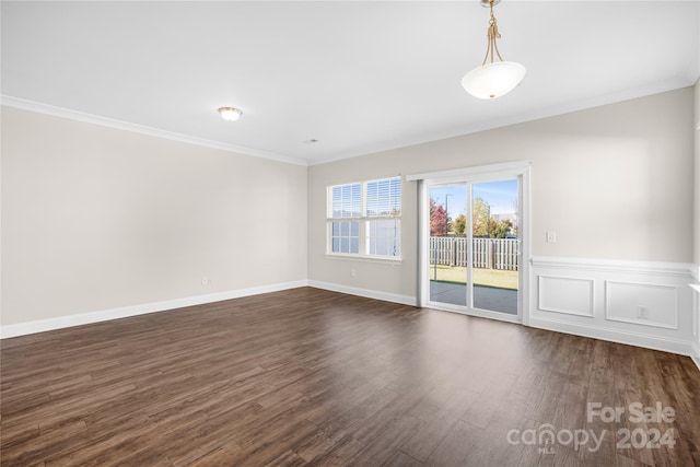 spare room featuring dark wood-type flooring and crown molding