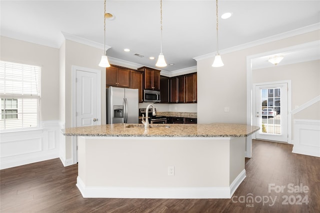 kitchen with light stone countertops, stainless steel appliances, dark wood-type flooring, sink, and decorative light fixtures