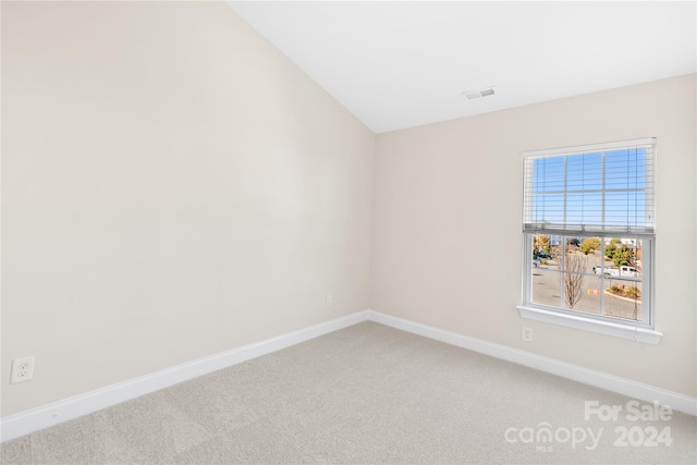 empty room featuring lofted ceiling and carpet floors