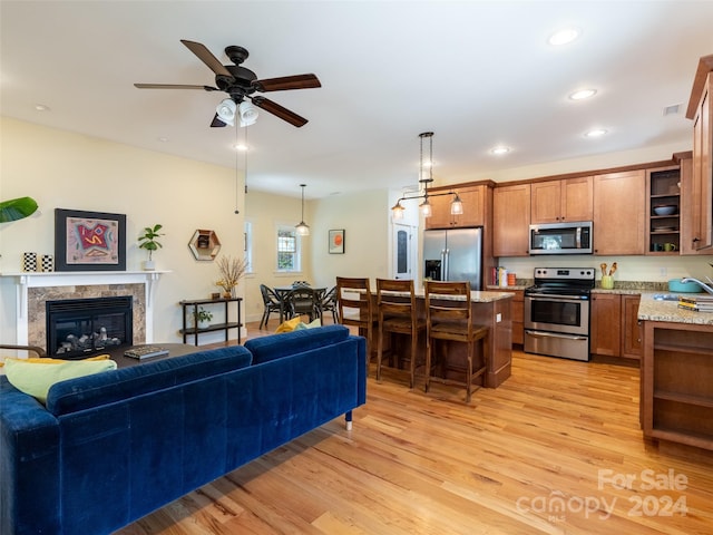 living room with light hardwood / wood-style floors, sink, and ceiling fan