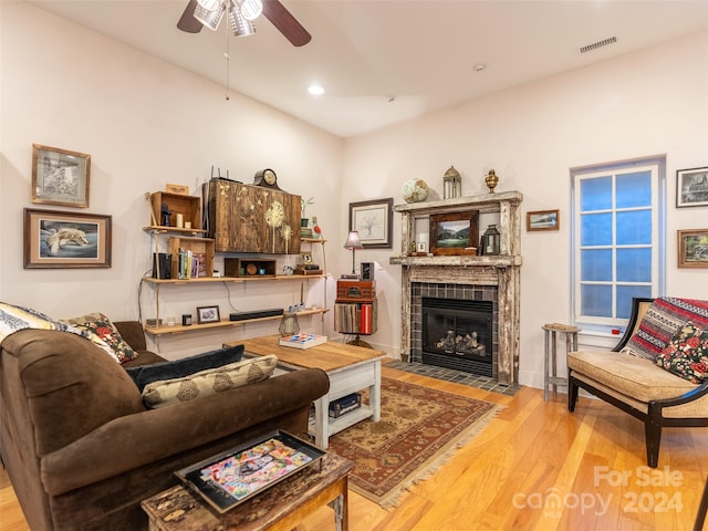 living room with a fireplace, wood-type flooring, and ceiling fan