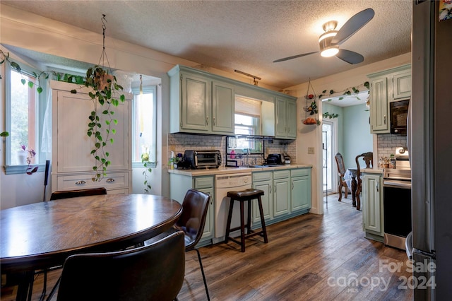 kitchen with decorative backsplash, dishwasher, dark wood-type flooring, stainless steel range oven, and ceiling fan