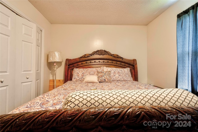 bedroom with a textured ceiling and a closet