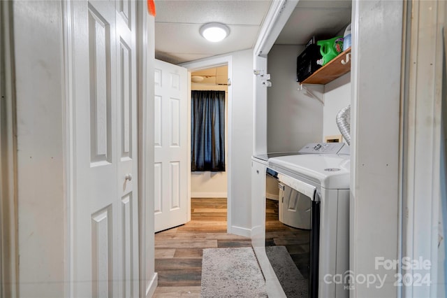 laundry room featuring light hardwood / wood-style flooring and washer and clothes dryer