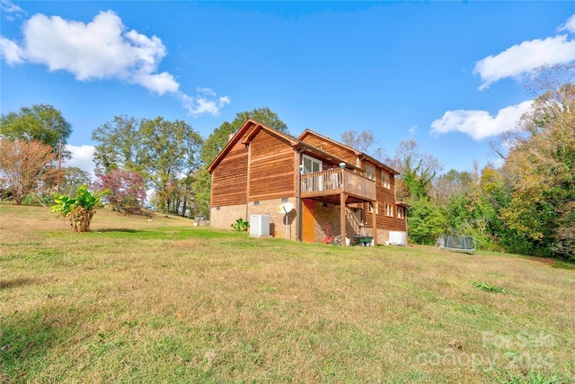 rear view of property featuring a lawn and a wooden deck