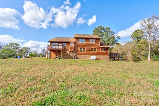 rear view of house featuring a wooden deck and a lawn