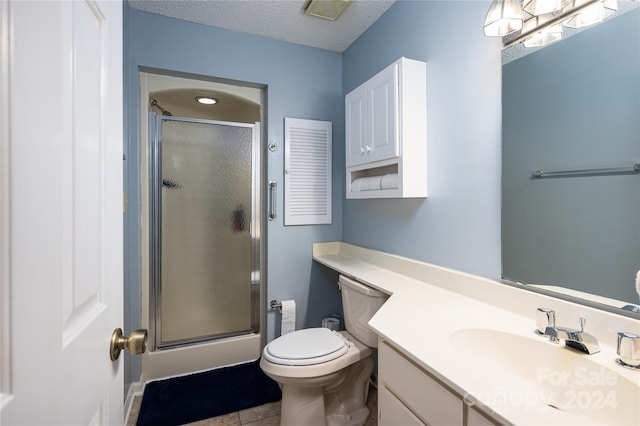 bathroom featuring vanity, toilet, a textured ceiling, and an enclosed shower