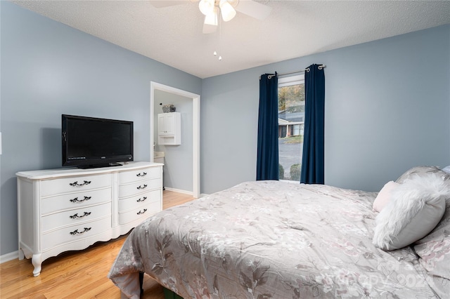 bedroom with light hardwood / wood-style floors, a textured ceiling, ensuite bathroom, and ceiling fan