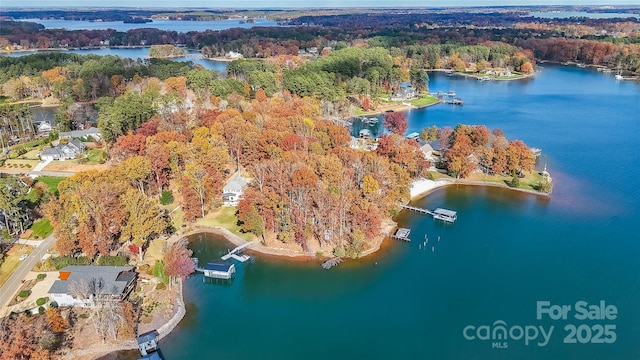 aerial view with a wooded view and a water view