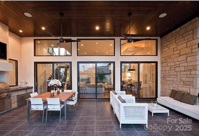 view of patio featuring ceiling fan, outdoor dining area, and exterior kitchen