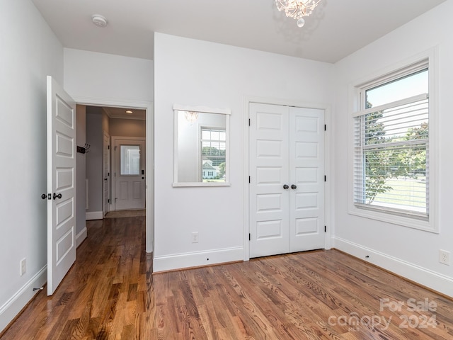 unfurnished bedroom with multiple windows and dark hardwood / wood-style floors