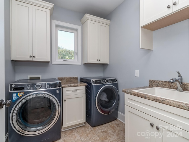 clothes washing area with sink, light tile patterned flooring, washing machine and dryer, and cabinets