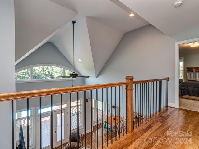 corridor featuring vaulted ceiling and wood-type flooring