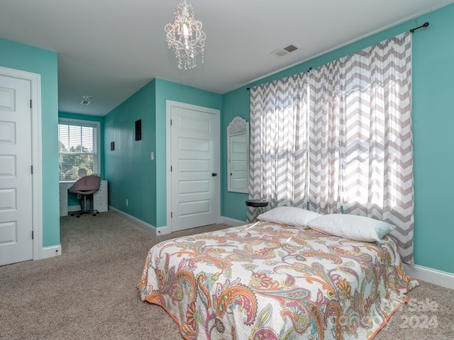 carpeted bedroom featuring a notable chandelier