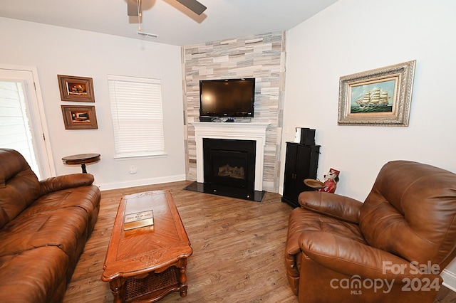 living room with wood-type flooring, a fireplace, and ceiling fan