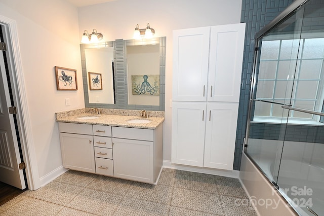 bathroom featuring vanity, tile patterned flooring, and bath / shower combo with glass door