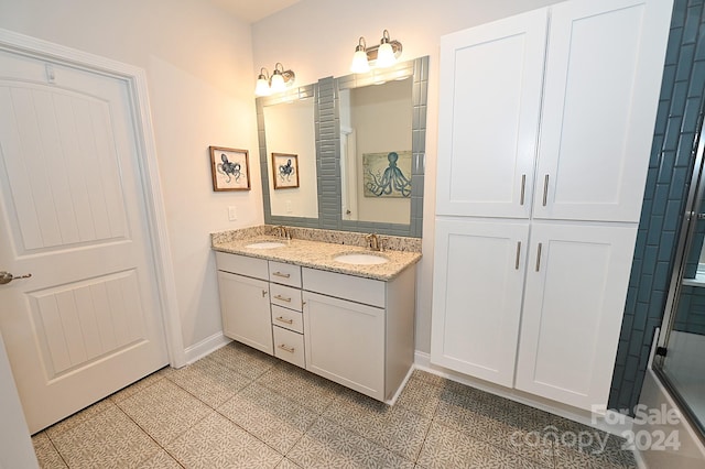 bathroom featuring vanity, a shower with shower door, and tile patterned flooring