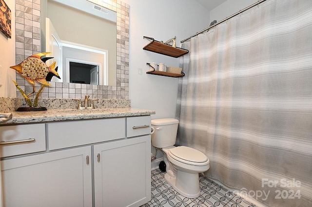 bathroom with decorative backsplash, toilet, vanity, a shower with curtain, and tile patterned floors