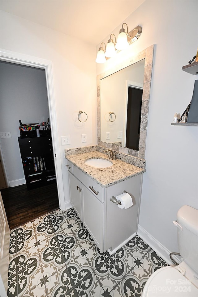 bathroom featuring vanity, toilet, and hardwood / wood-style flooring