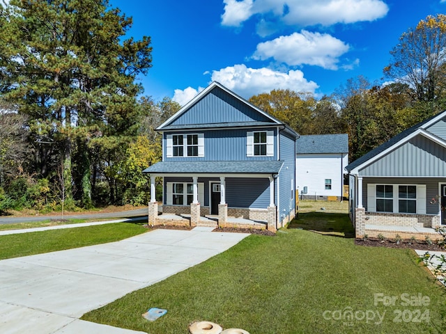 view of front of home with a front yard and a porch