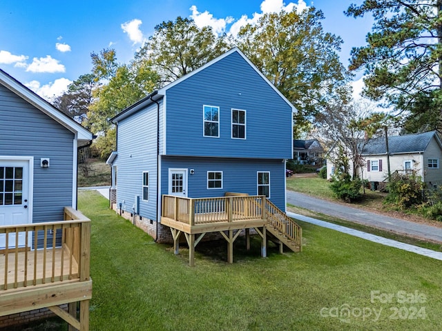 rear view of house with a deck and a lawn