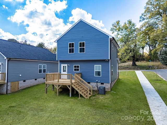 rear view of property with a yard and a wooden deck