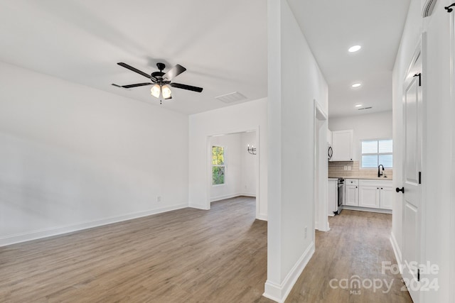 interior space with sink, light wood-type flooring, and ceiling fan