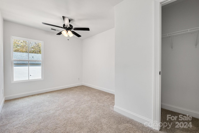 unfurnished bedroom featuring a closet, ceiling fan, and light colored carpet