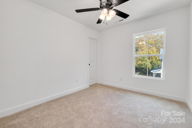 carpeted spare room featuring ceiling fan