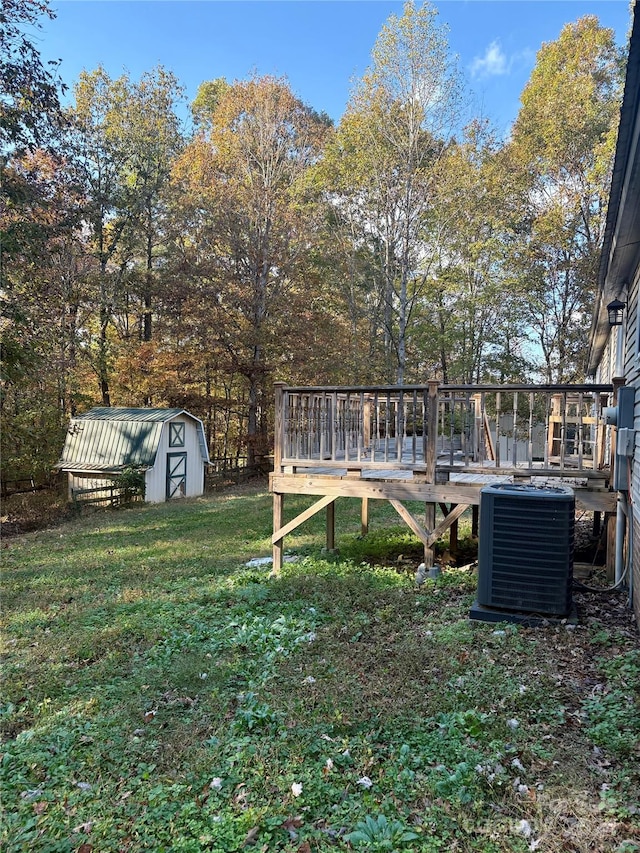 view of yard with central air condition unit, a wooden deck, and a shed