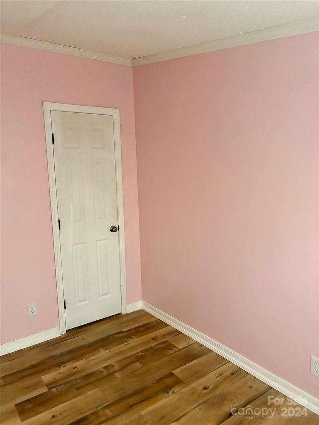 empty room featuring hardwood / wood-style flooring and ornamental molding