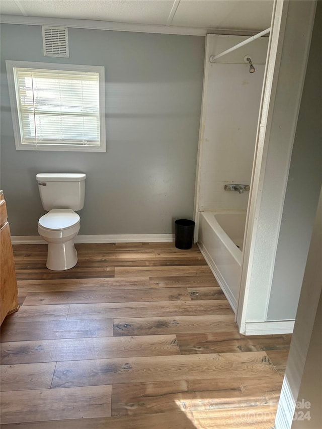 bathroom featuring hardwood / wood-style floors, toilet, and  shower combination