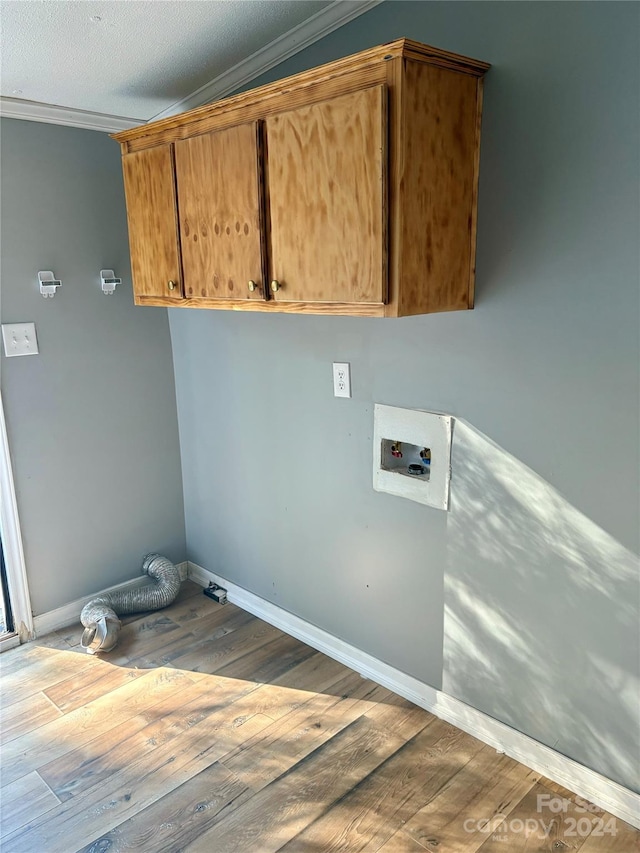 washroom featuring ornamental molding, hardwood / wood-style floors, washer hookup, and cabinets