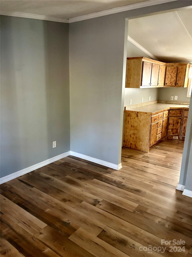 kitchen with ornamental molding and wood-type flooring