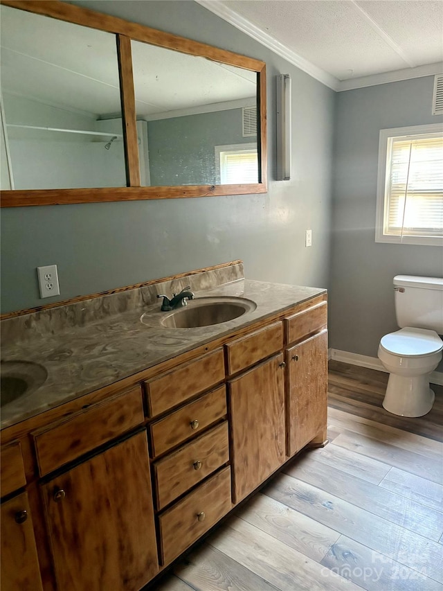 bathroom featuring ornamental molding, hardwood / wood-style floors, vanity, and toilet